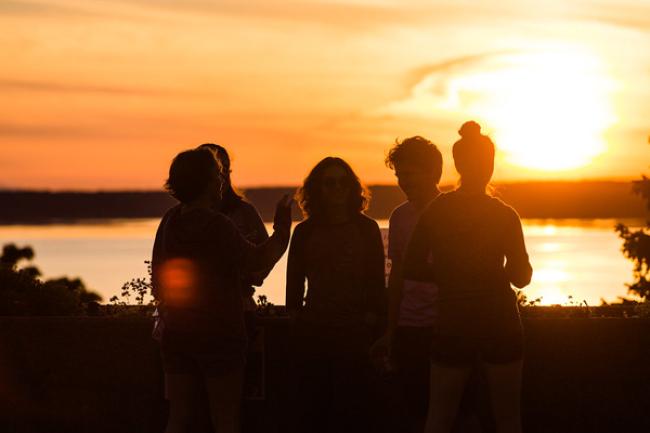 A group of WWU students together overlooking Bellingham Bay at sunset